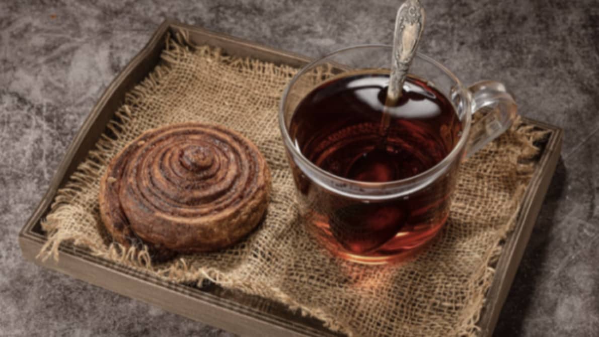 Cinnamon Buns Vs Cinnamon Rolls, a tray with cup of tea