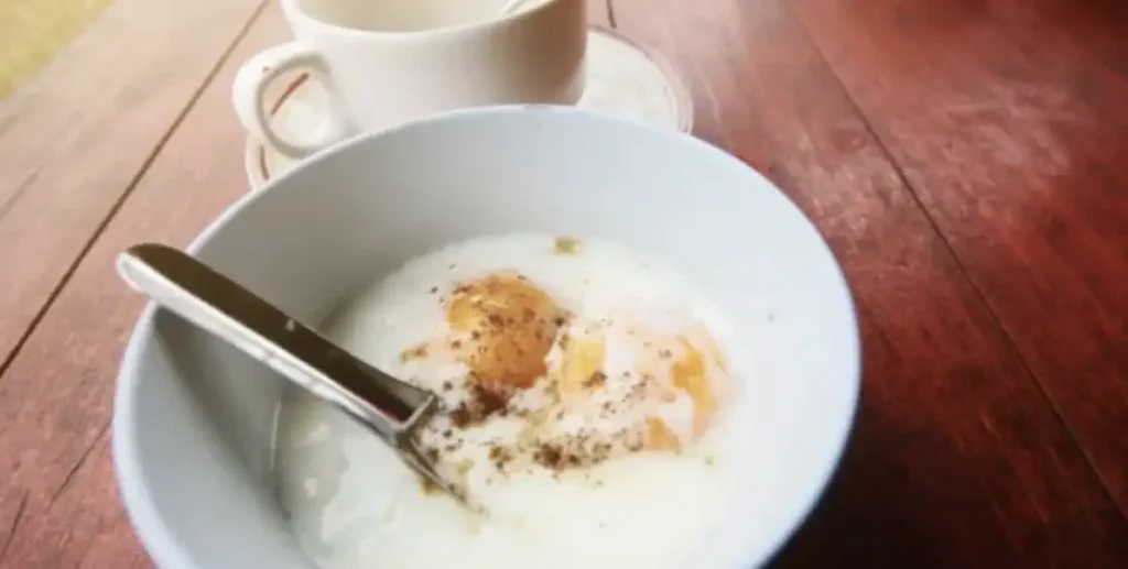 fried eggs, eggs in a white bowl next to cup od tea